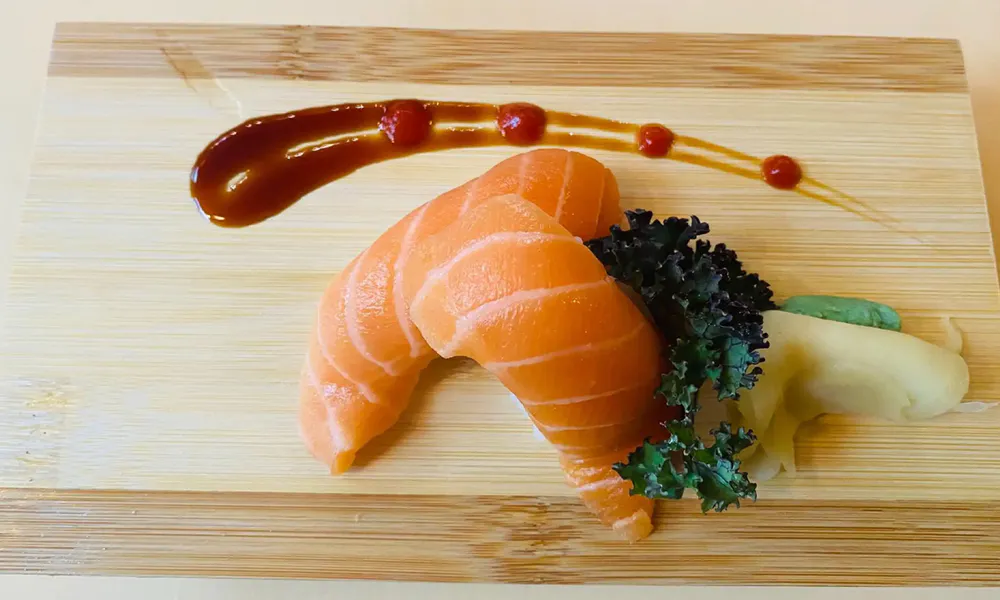 Raw fresh salmon nigiri sushi wooden board teriyaki drizzle garnish at Osaka Hibachi & Sushi, a Japanese Restaurant in Bainbridge